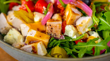 Healthy fresh salad with vegetables, chicken on plate. Homemade delicious lunch with chicken, bell pepper, olives, arugula for restaurant, menu, advert or package, close up selective focus - 723253861