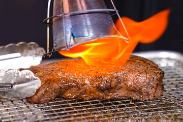 Beef steak grilled fillet meat with flame. Homemade cooking beef steak, serving food for restaurant, menu, advert or package, close up, selective focus - 723255404
