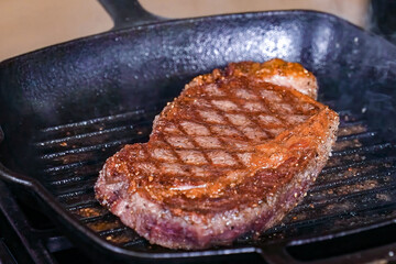 Beef steak grilled fillet meat with spices on a hot grill. Homemade roasted beef steak, serving food for restaurant, menu, advert or package, close up, selective focus - 723255410