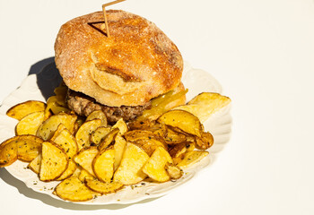 Homemade hamburger served with rustic potatoes ready to eat