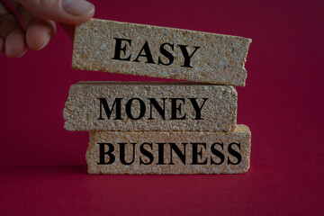 Easy money business symbol. Concept words Easy money business on brick blocks. Beautiful red background. Businessman hand. Easy money business concept. Copy space.