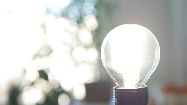 Blurred Shooting with a Person Starting the Led Light Bulb in a Room Using Smartphone App. Low Energy Consumption Concept with Led Lighting Technology. Powering On the Light in a Room. 