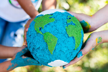 Children Holding Handmade Painted Globe in Nature