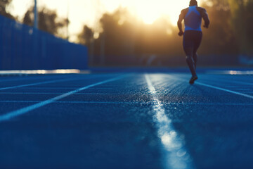 Fototapeta na wymiar Athlete Running on Track at Sunset, Training for Performance and Speed.