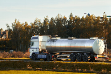 Fototapeta na wymiar A White Tank Truck on the road Delivering Goods Safely including liquid petroleum gas LPG or propane.