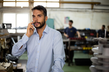 The engineer supervises the production of electrical devices in the factory.