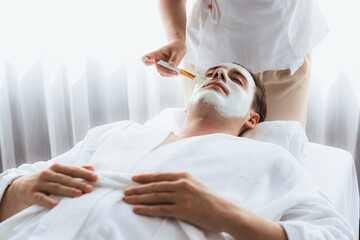 Serene ambiance of spa salon, man customer indulges in rejuvenating with luxurious face cream...