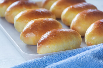 Freshly baked ruddy buns on a white tray