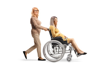 Middle aged woman pushing a pregnant woman in a wheelchair