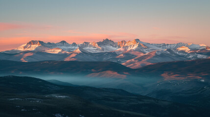 A majestic mountain range at sunset with peaks covered in snow.