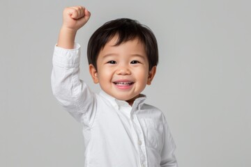 Triumphant Asian Boy, One Year Old, Celebrates With Fist Pump - Perfect Symmetrical Photo