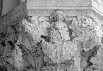 Venice, Italy, Sept. 17, 2023: A man writing is one of many diverse carvings made by the city’s medieval Stone-Carvers Guild to decorate the column capitals in the Doge’s Palace portico.