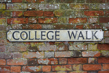 Vintage English road sign for College Walk in historic city of Winchester. 