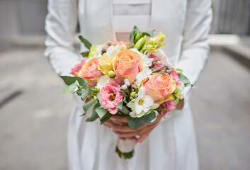 Tender hands cradle a bridal bouquet