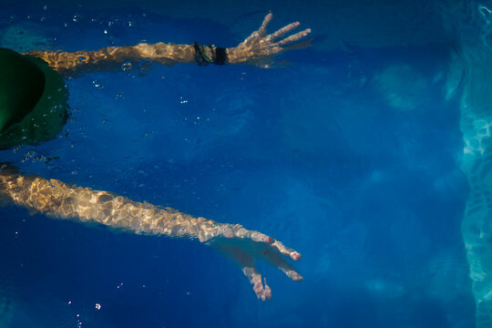 The arms of a young woman in a swimming pool