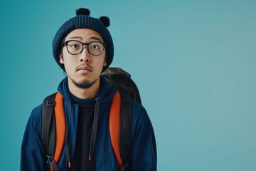 Fototapeta premium Asian Student With Backpack And Glasses Glimpse At Empty Space For Ads