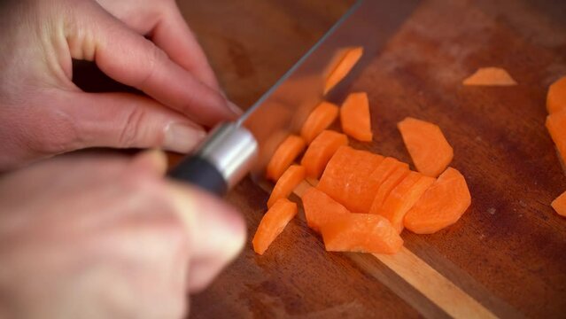 Slicing carrots on chopping board