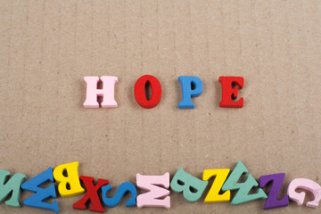 HOPE word on paper background composed from colorful abc alphabet block wooden letters, copy space for ad text. Learning english concept.