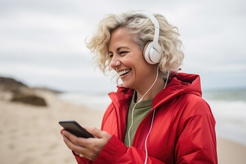 A woman wearing headphones and listening to music on a cell phone. Perfect for illustrating the enjoyment of music or using technology for entertainment purposes
