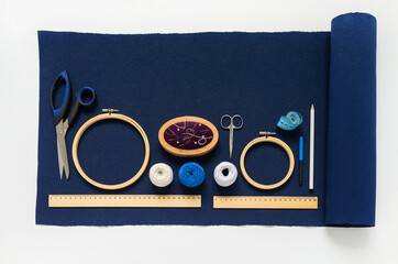 Top view of accessories for hand embroidery in Sashiko style: blue canvas, white threads,...