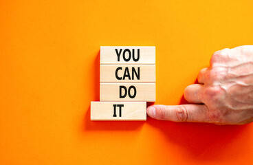 You can do it symbol. Concept word You can do it on beautiful wooden block. Beautiful orange table orange background. Businessman hand. Business motivational you can do it concept. Copy space. - Powered by Adobe