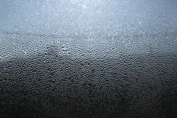 Closeup of heavy water condensation on window glass during a winter morning. 