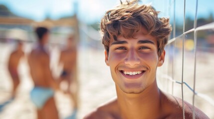 A young guy smiling looks at the camera. He plays beach volleyball with friends