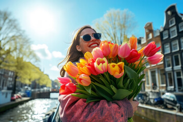 Young woman with a big bunch of colorful tulips in her arms