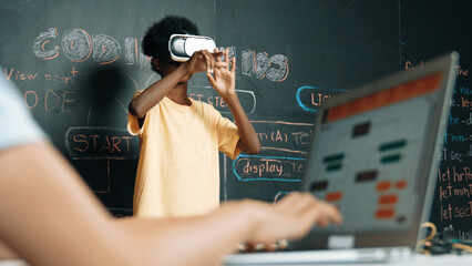 Closeup of school girl hand coding program while african student using VR interact with metaworld....