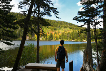 Male hiker with backpack looking over Bear Lake in Colorado Rocky Mountain National Park