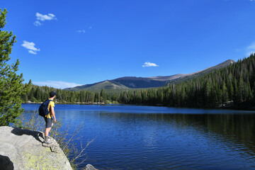 Fototapeta na wymiar Male hiker with backpack looking over Bear Lake in Colorado Rocky Mountain National Park