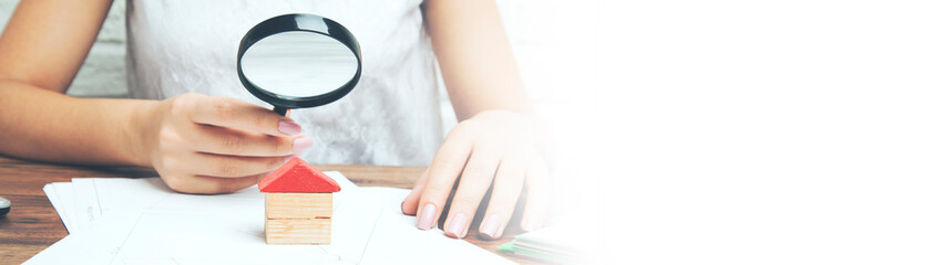 Businesswoman hand magnifier and house model