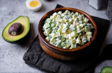 Egg cucumber avocado salad with mayonnaise sauce in a bowl