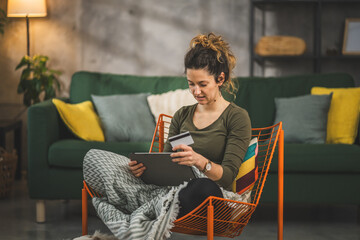 young woman caucasian female hold credit card online shopping at home