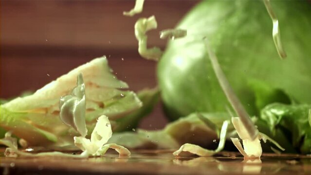 The shredded cabbage falls onto the cutting board. Filmed on a high-speed camera at 1000 fps. High quality FullHD footage