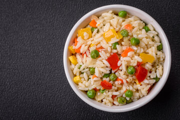 Delicious white boiled rice with vegetables, sweet peppers, carrots, peas