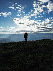 silhouette of a person walking on a hill