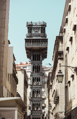 Sun-kissed morning in Lisbon! Iconic Santa Justa Elevator rises against a clear summer sky,...