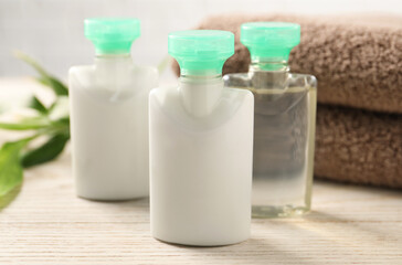 Mini bottles of cosmetic products on white wooden table