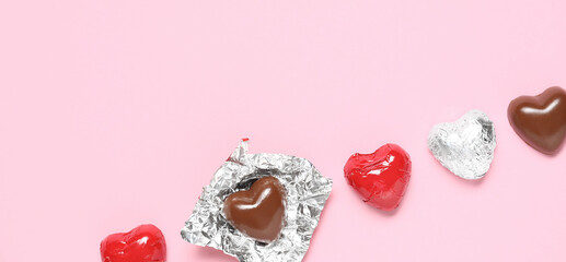 Tasty heart-shaped chocolate candies on pink background. Valentine's Day celebration