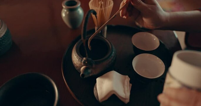 Herbs, teapot and Japanese woman with tea with traditional leaves and indigenous recipe in home. Cup, ceremony and hands of person with herbal beverage for health, wellness and detox for drinking