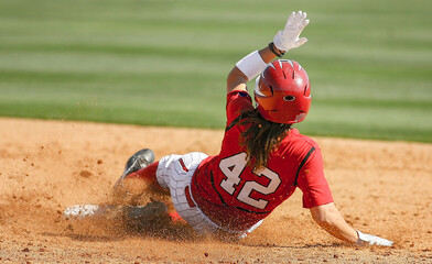 An American softball player slides into base during game action. 