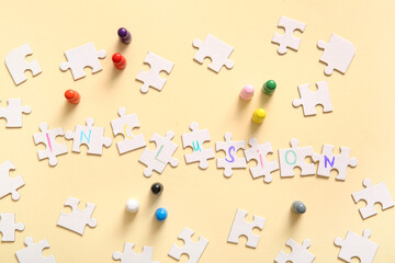 Puzzle pieces with word INCLUSION and pawns on beige background