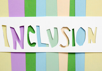 Word INCLUSION on colorful paper, top view
