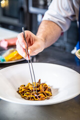 Chef prepara setas de temporada salteadas con yema de huevo curada con salsa de soja y flores...