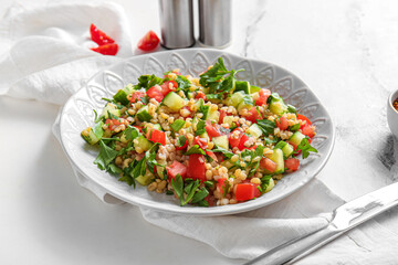 Plate with delicious tabbouleh salad on light background, closeup