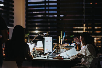Diverse business team collaborating late at night to meet deadlines and discuss growth strategies....