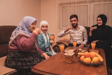 Happy Muslim family drinking Turkish coffee after dessert at home during the Eid Mubarak Ramadan.