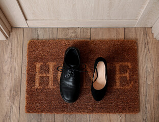 Doormat with shoes in hall, top view