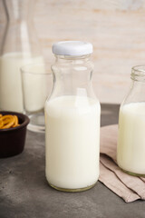 Milk in jar and glass on the grey background.